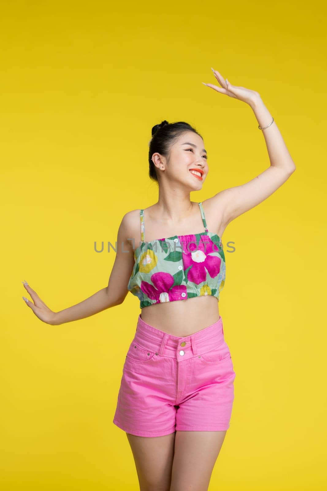 Happy, excited and woman dance, celebration and cheerful against a yellow background. by makidotvn