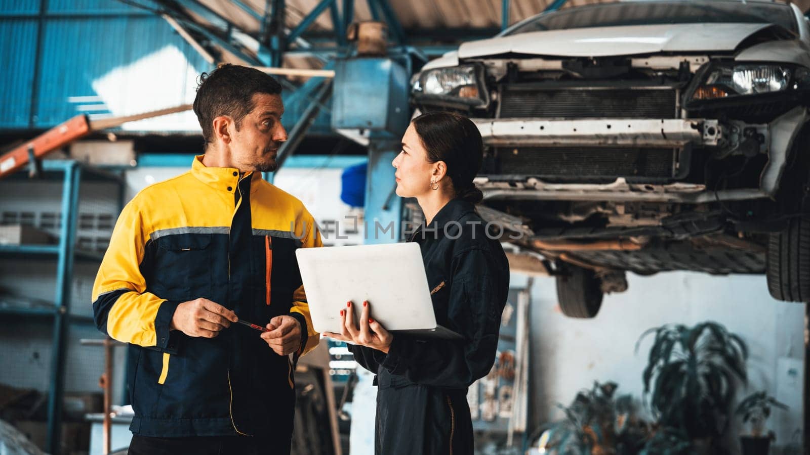 Two vehicle mechanic working together, conduct car inspection with laptop. Oxus by biancoblue