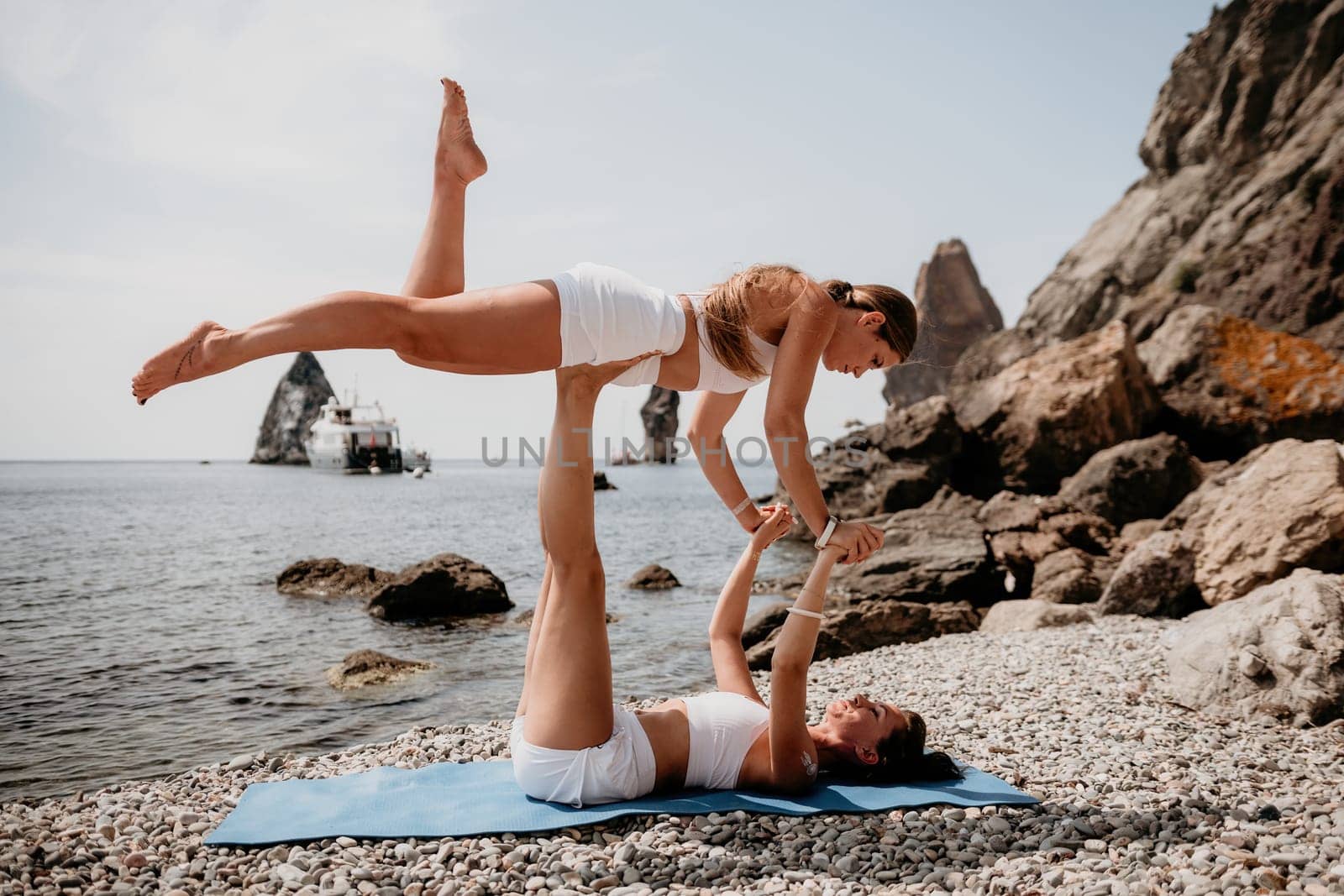 Woman sea yoga. Back view of free calm happy satisfied woman with long hair standing on top rock with yoga position against of sky by the sea. Healthy lifestyle outdoors in nature, fitness concept.