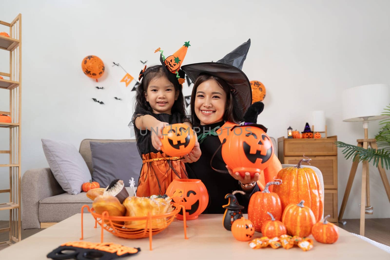 Happy family mother and child happy girl with Halloween at home together beautifully decorated by nateemee