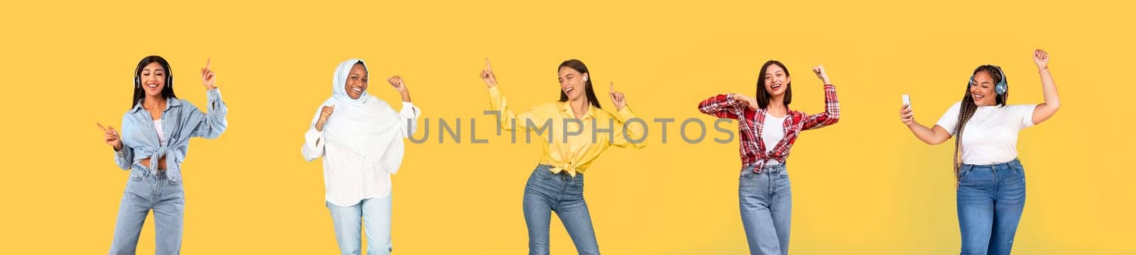 Cheerful international millennial women in wireless headphones dance, have fun, enjoy fun, entertainment, free time, isolated on yellow studio background, panorama. Lifestyle, ad and offer