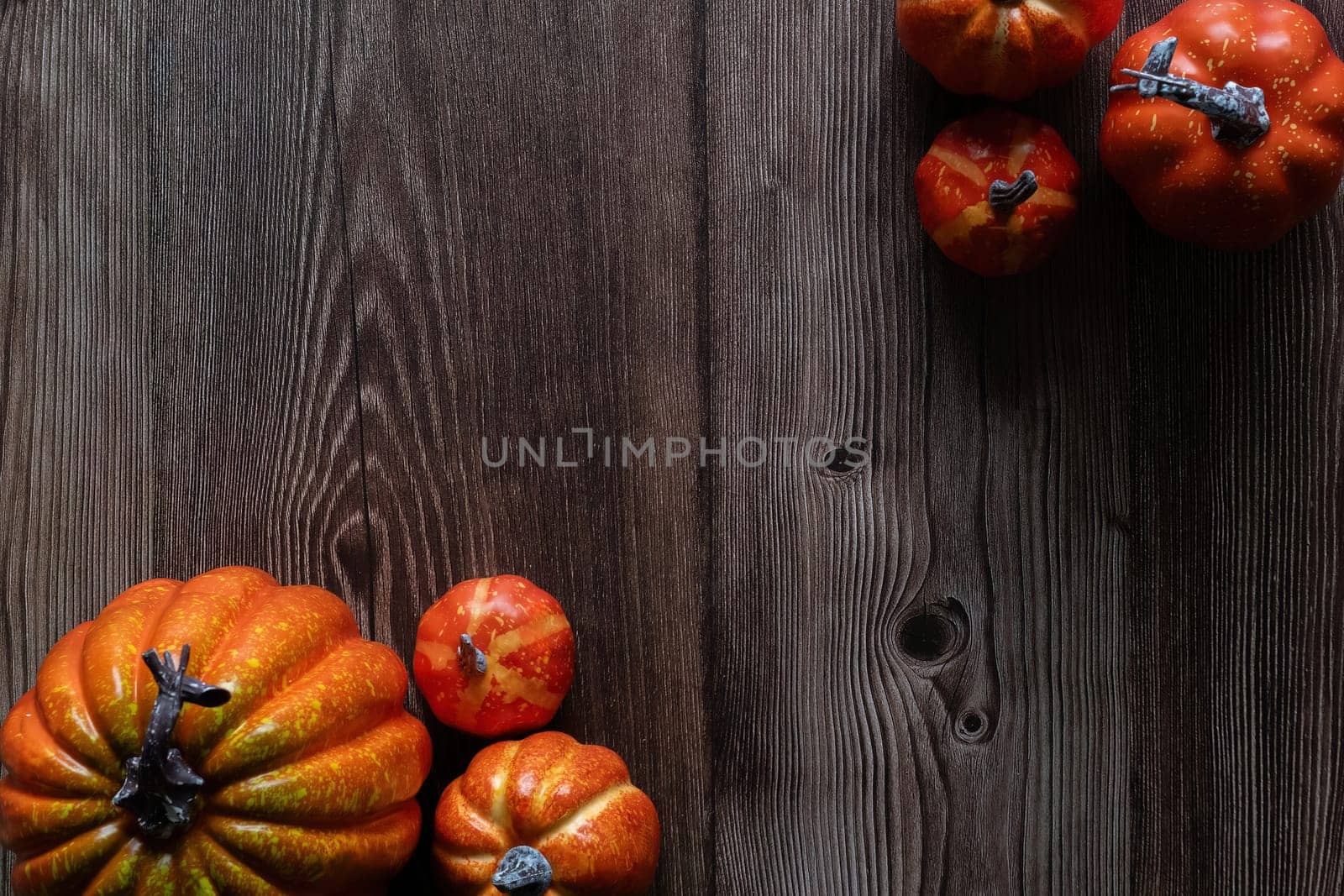 Top view Halloween concept Pumpkin decorations and black paper bat flying over the wooden floor. by wichayada