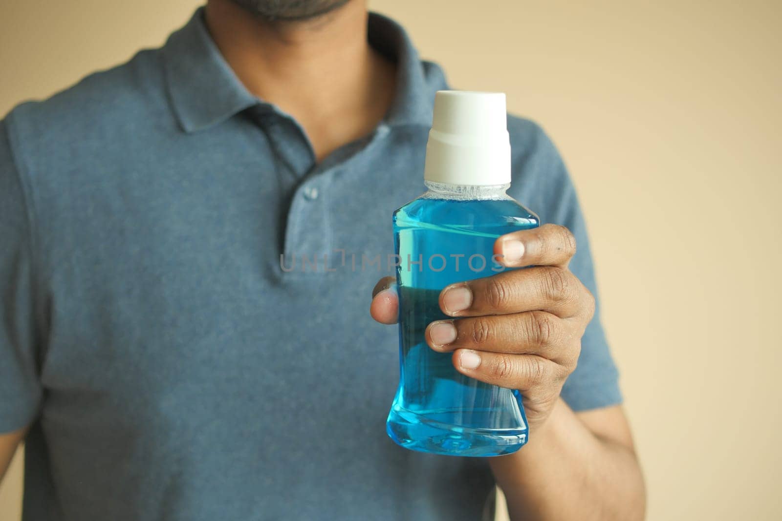hand hold a mouthwash liquid container .