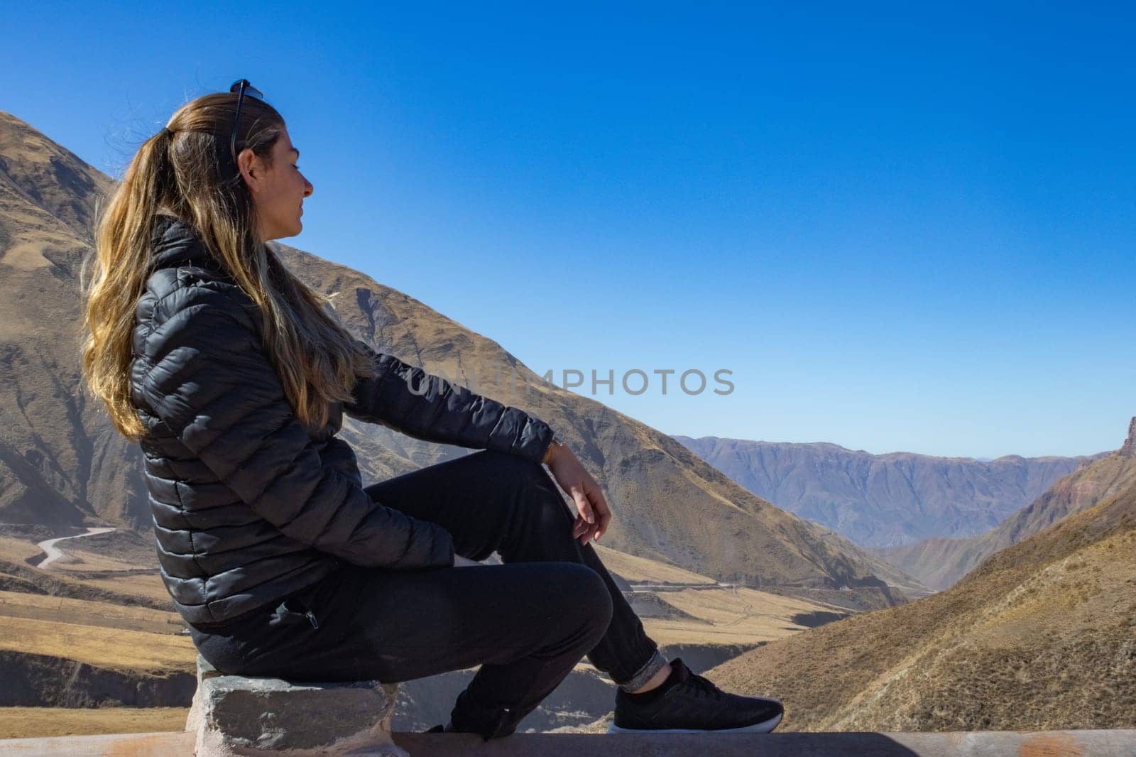 Young woman enjoying nature.Background for tourism ads.Winter Adventure tourism.Wallpaper in brown tones.Landscape of Salta. Copy space.Real picture
