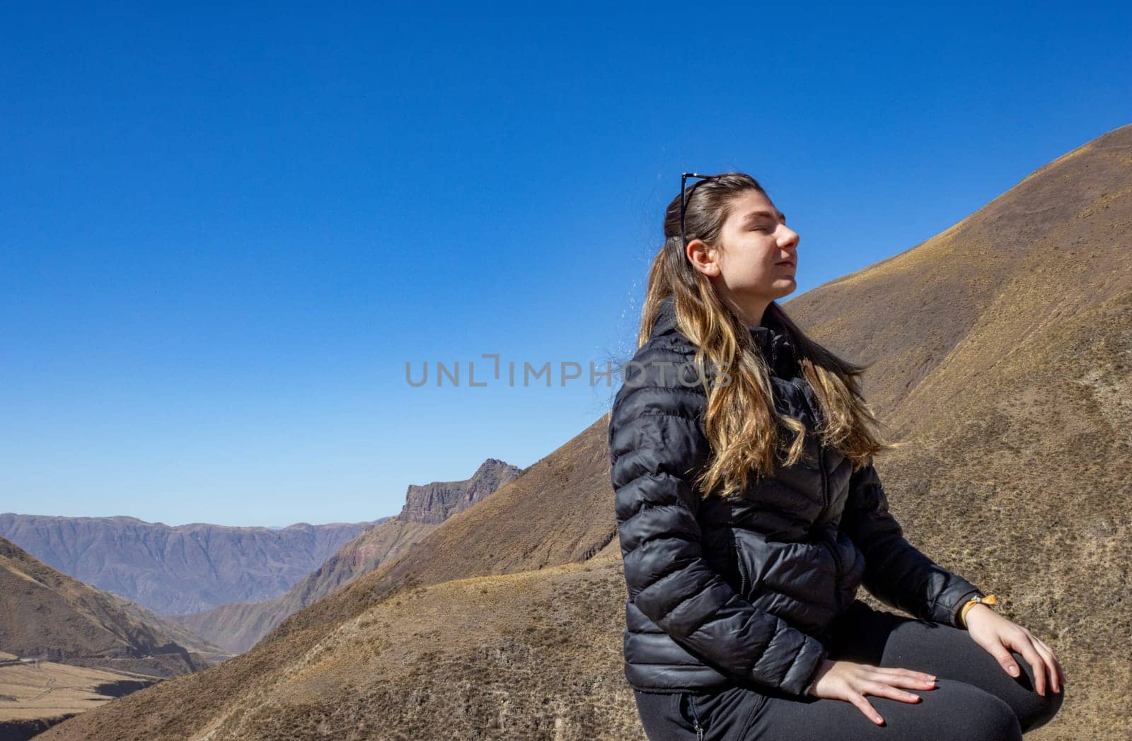 Background for tourism ads.Young woman enjoying nature.Winter Adventure tourism.Wallpaper .Landscape of Salta. Copy space.Real picture