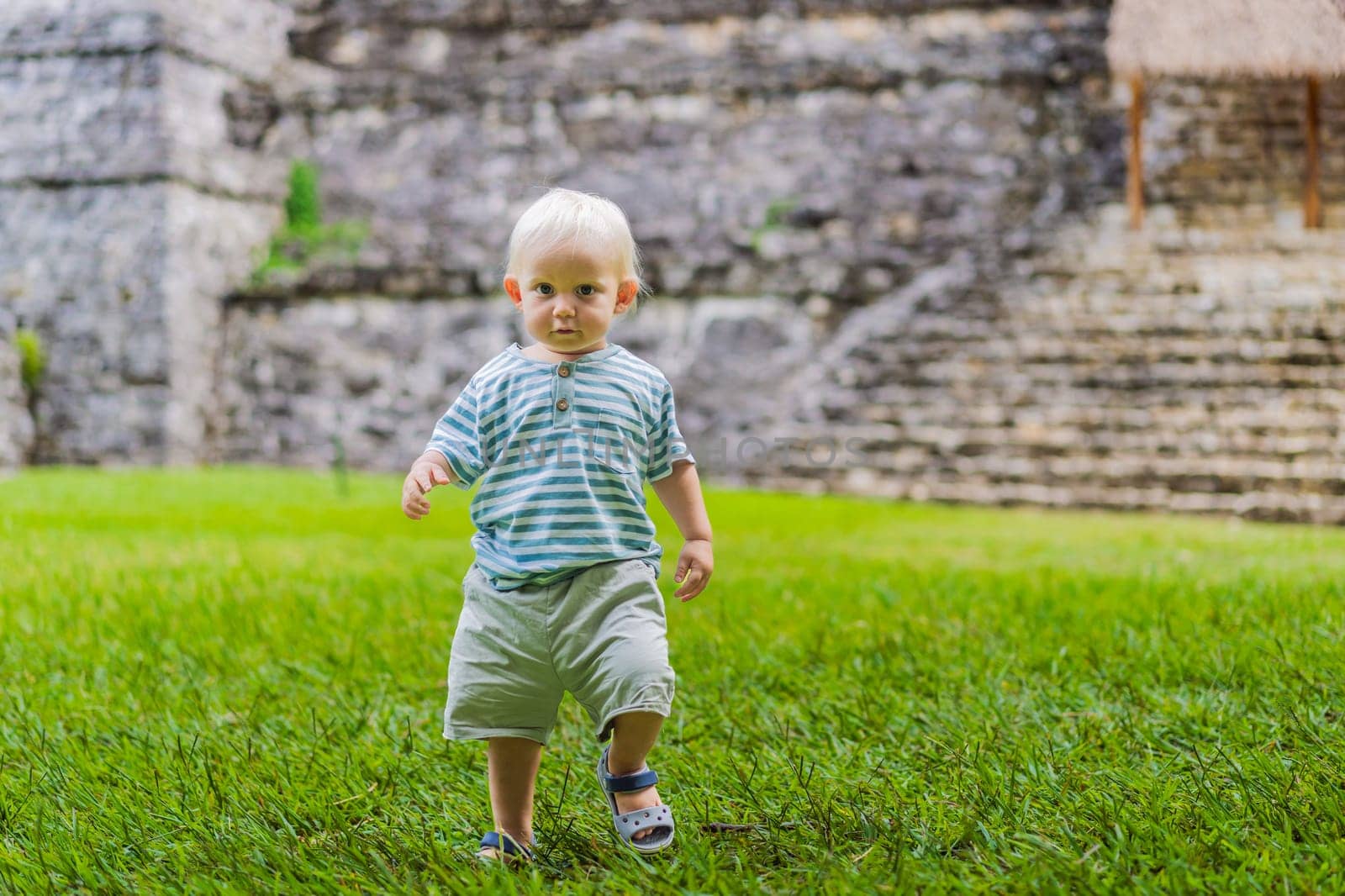 Baby tourist exploring the ancient pyramids of Palenque, Mexico, surrounded by dense jungle. Cultural heritage and adventure travel concept.