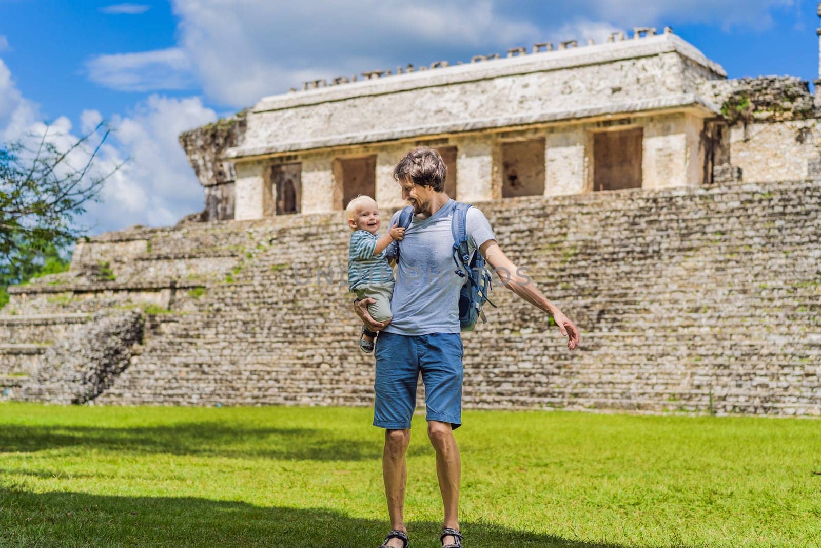 Mother with his toddler son exploring the ancient pyramids of Palenque, Mexico, surrounded by dense jungle. Cultural heritage and adventure travel concept.