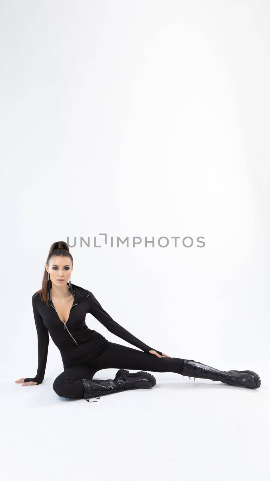 A striking fashion model poses elegantly in a sleek black bodysuit, showcasing style and confidence.