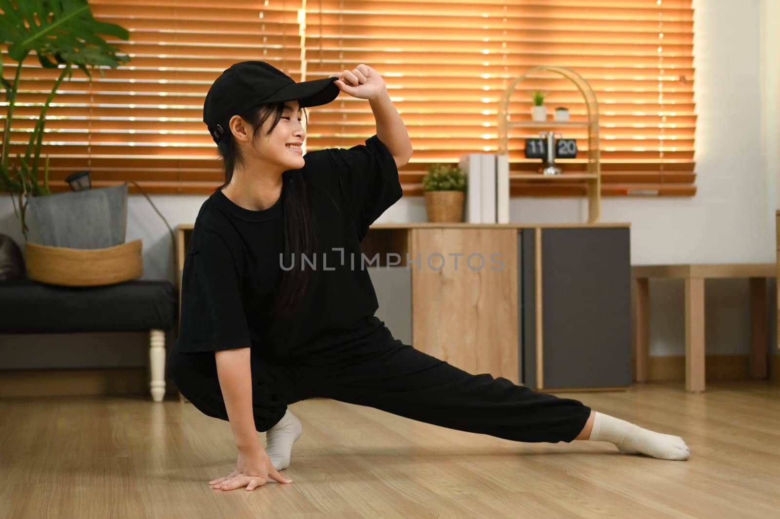 Energetic teenage girl practicing Hip Hop dance at home.