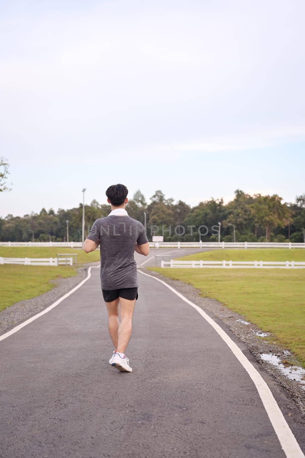 Athletic man jogging in a peaceful park. Fitness and healthy lifestyle concept.