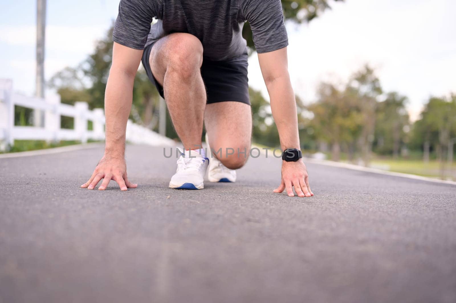 Athlete man in starting position ready for sprint. Goals and motivation concept.