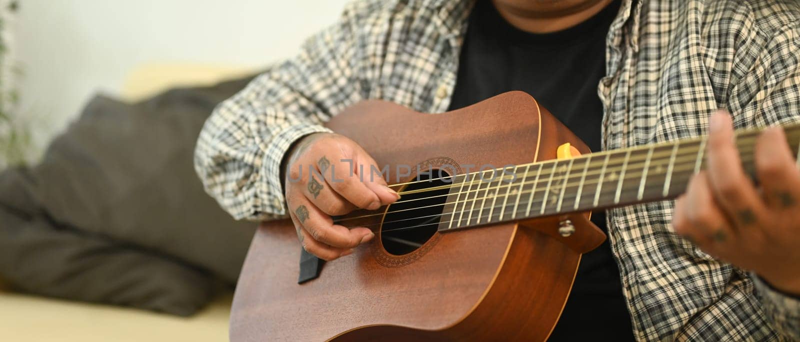 Close up of man playing acoustic guitar. Leisure activity and hobby concept.