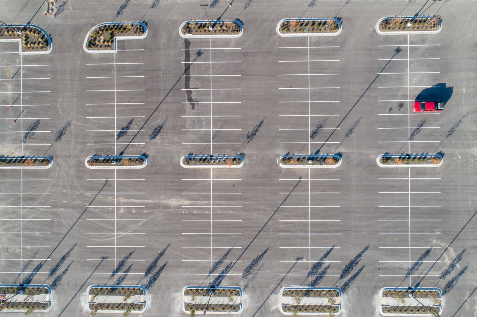 top view of a single car in a mostly empty parking lot