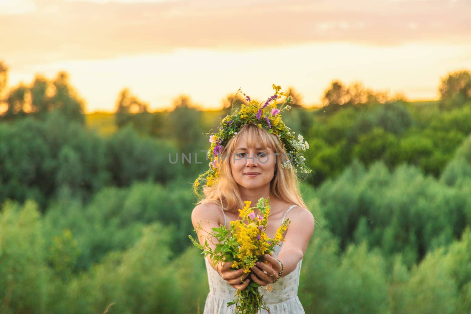 Woman in a meadow with medicinal herbs. Selective focus. Nature.