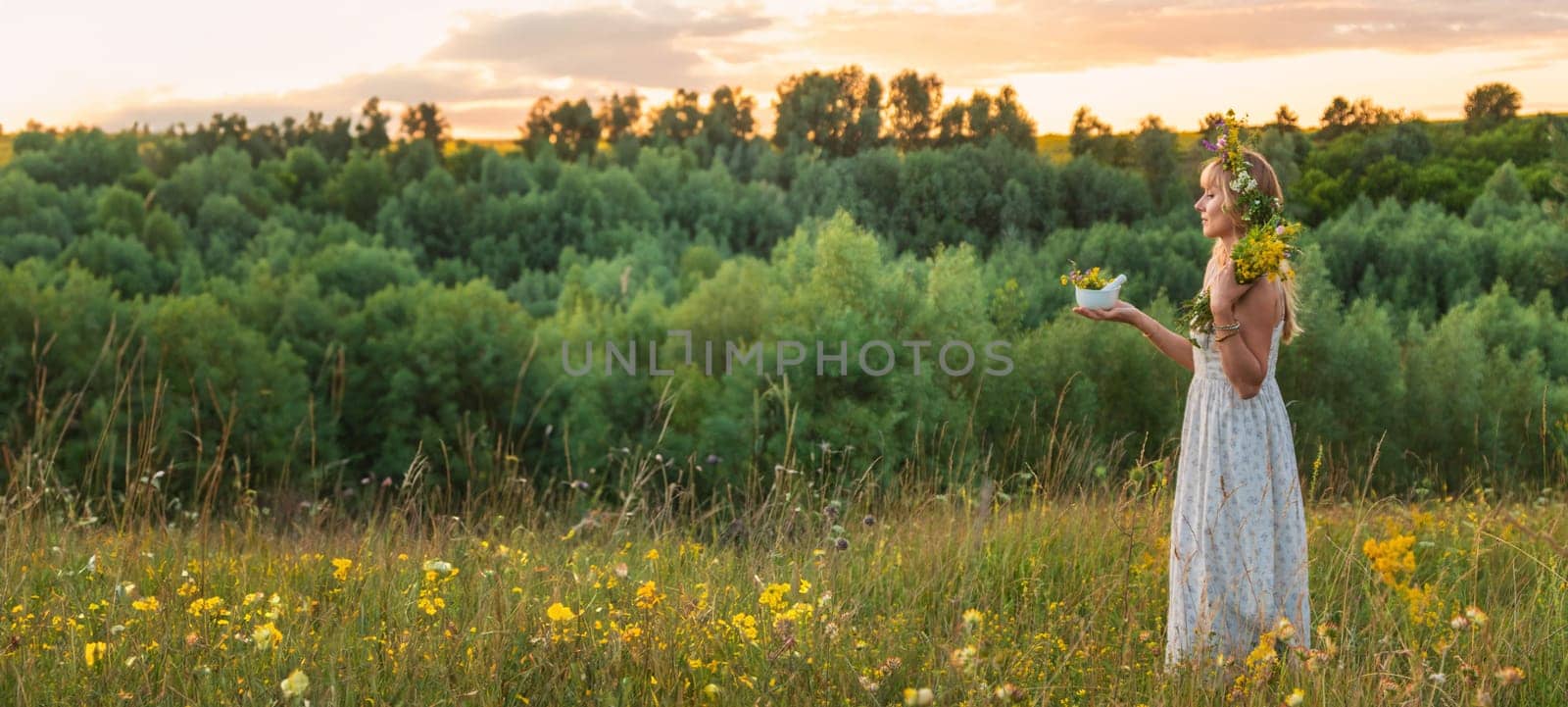 Woman in a meadow with medicinal herbs. Selective focus. Nature.