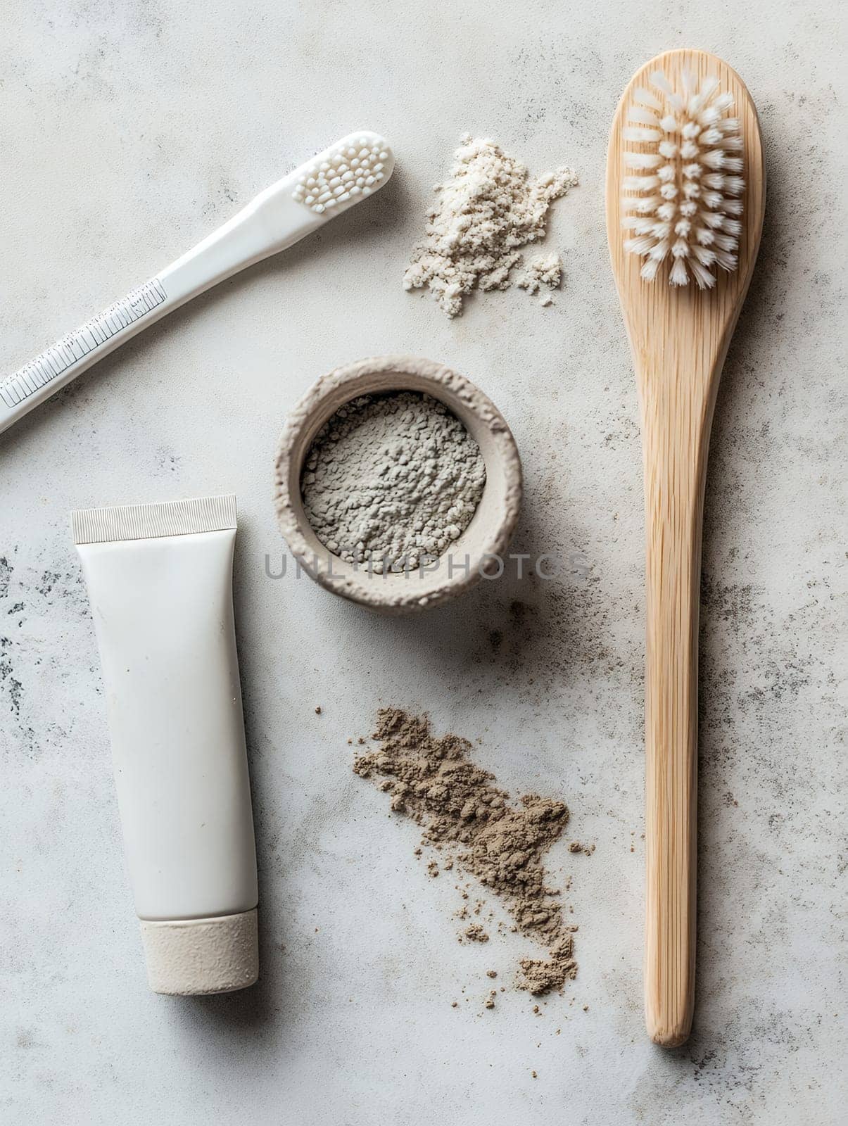 An eco-friendly dental care set with bamboo toothbrush, toothpaste, and natural powders on a light surface.