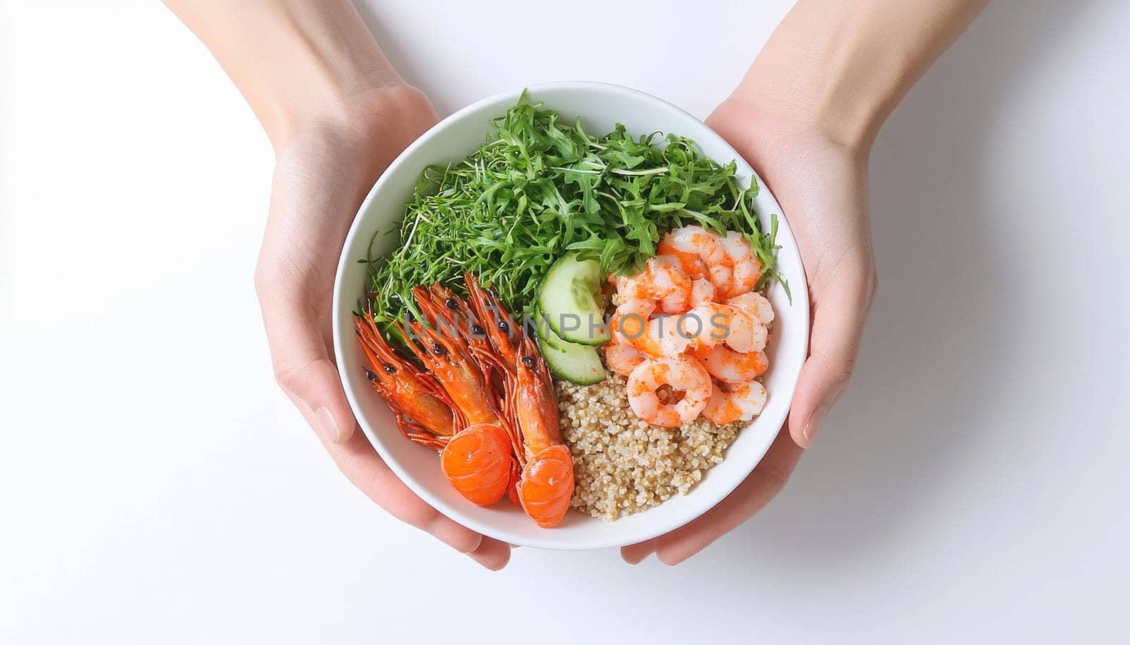 Woman holding a white bowl filled with a healthy lunch of quinoa, shrimp, and arugula