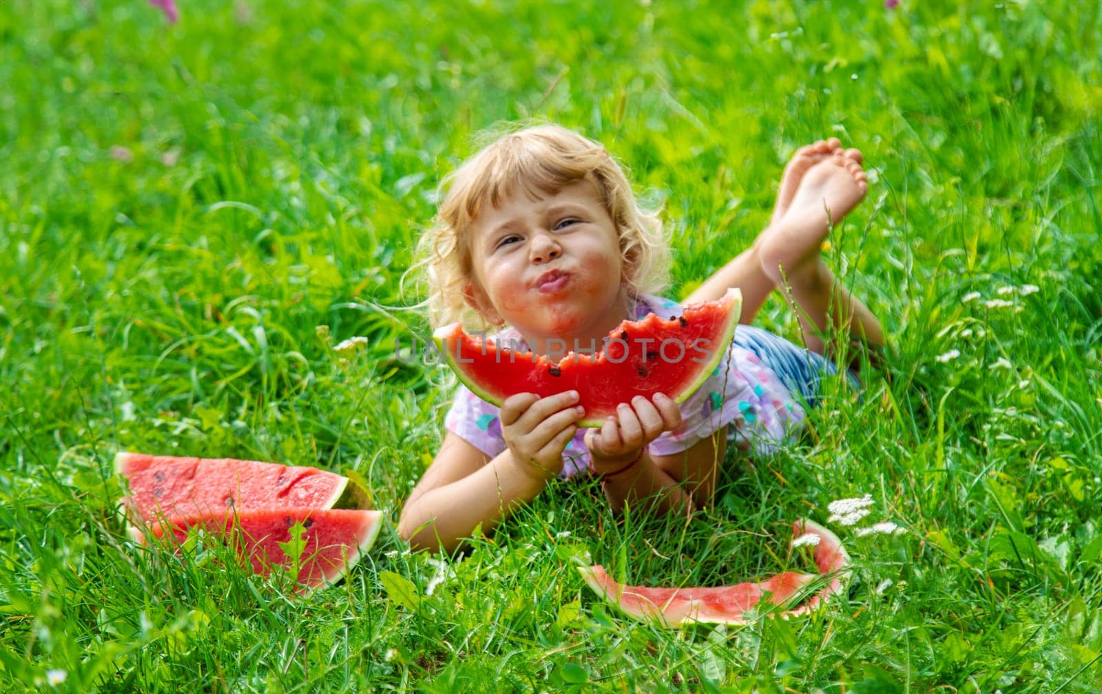 Child eats watermelon in summer. Selective focus. Kid.