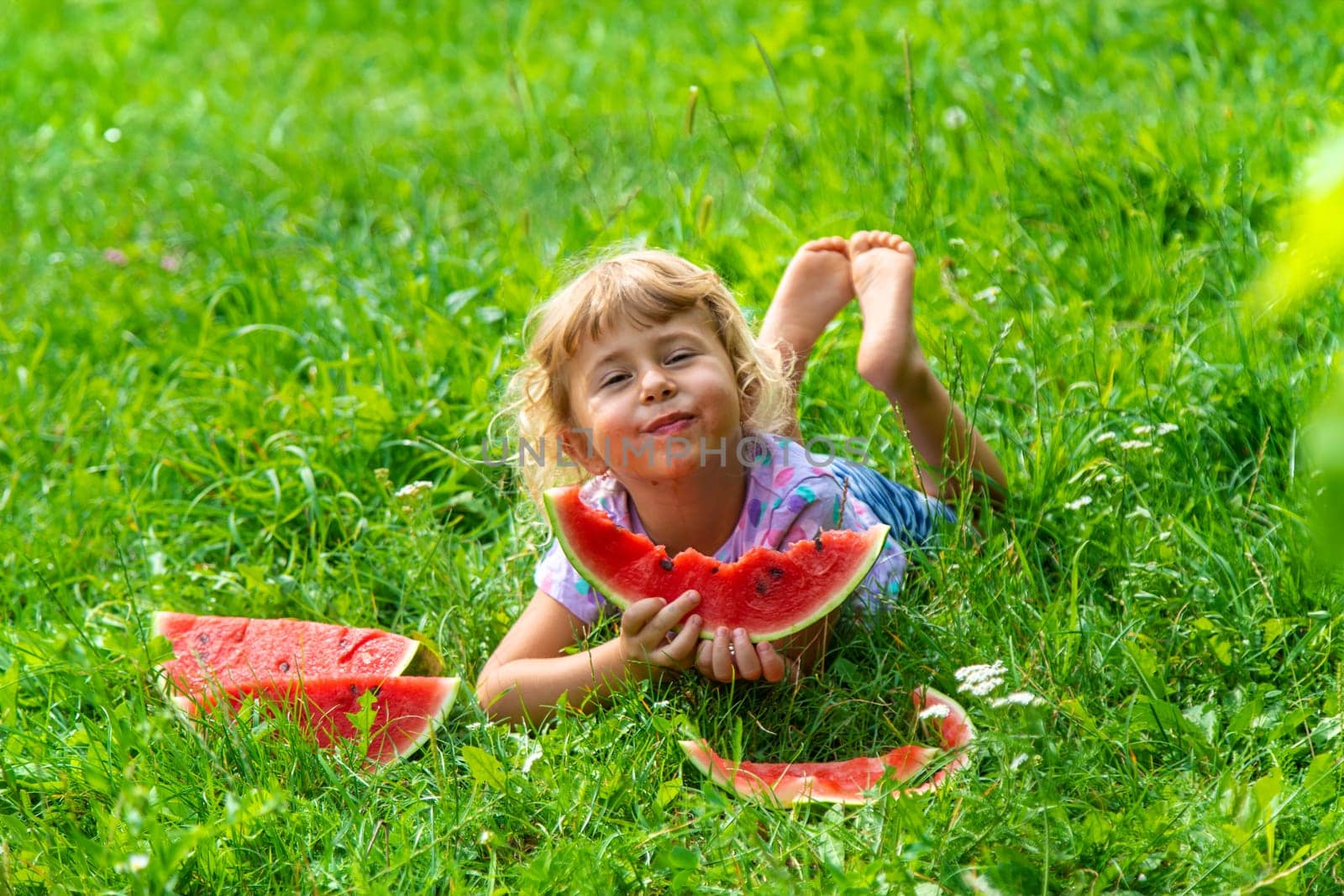 Child eats watermelon in summer. Selective focus. Kid.