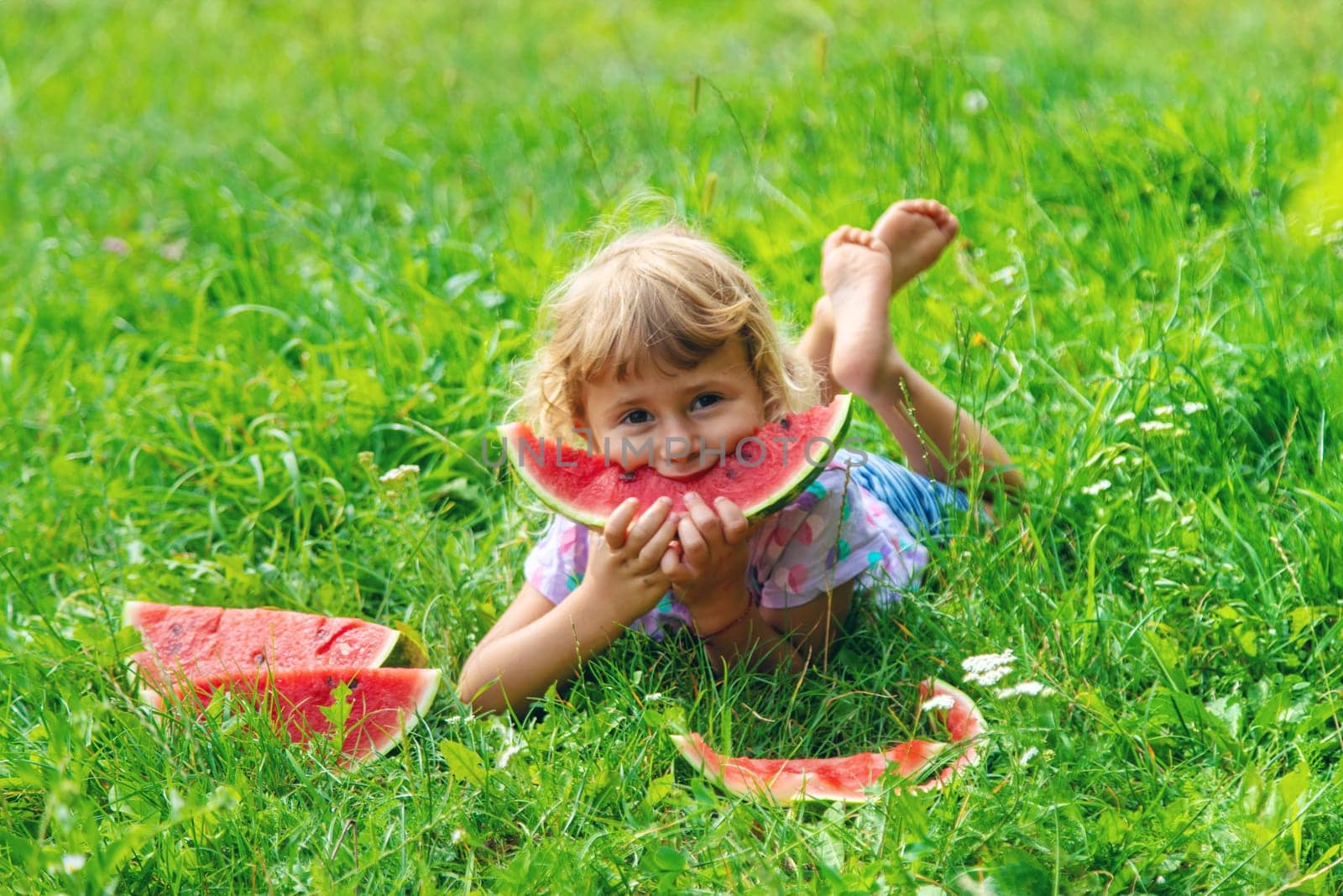Child eats watermelon in summer. Selective focus. Kid.