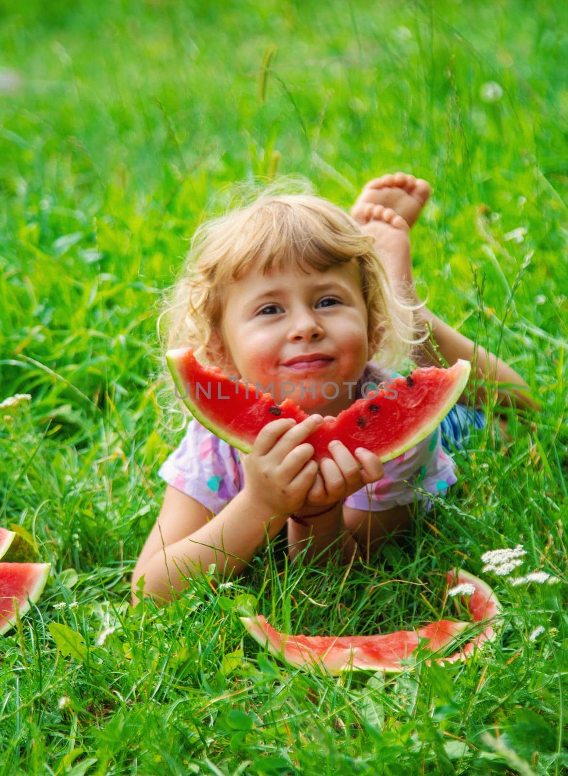 Child eats watermelon in summer. Selective focus. Kid.