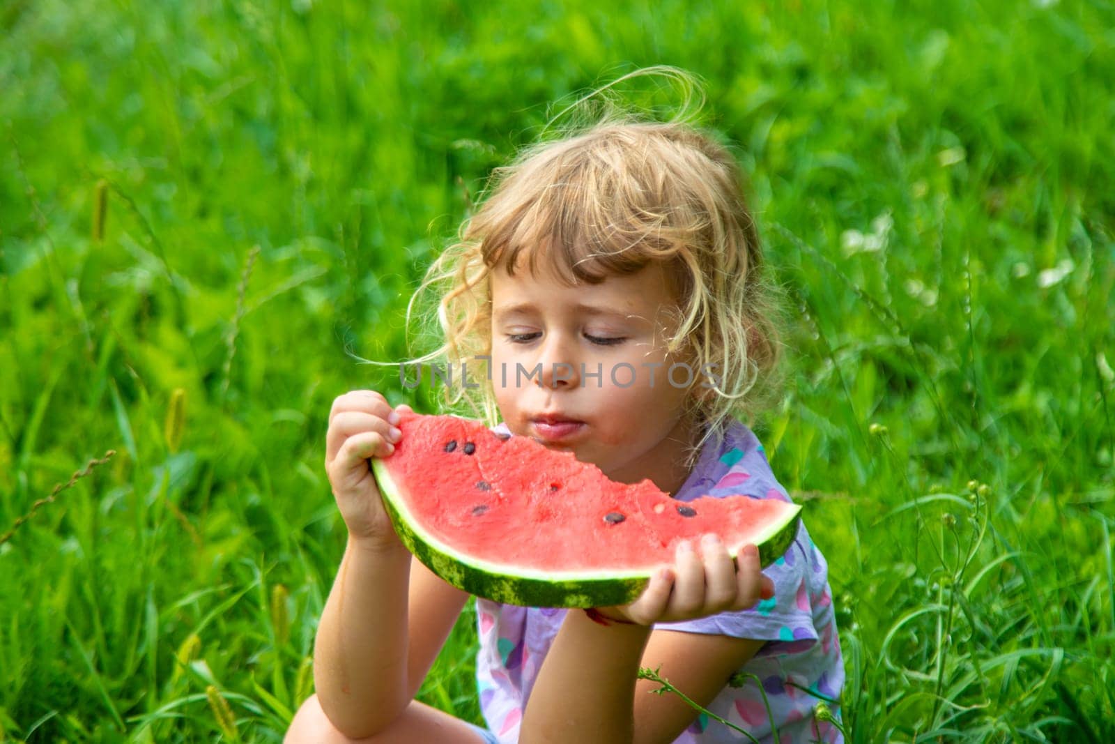 Child eats watermelon in summer. Selective focus. Kid.