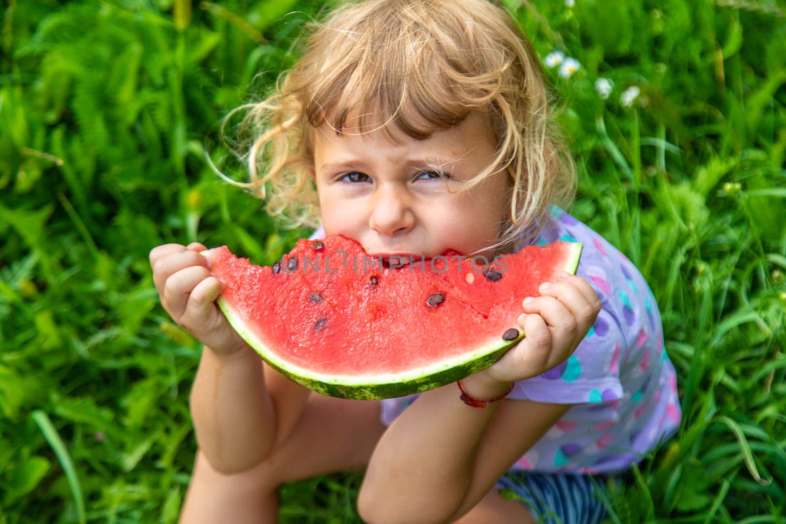 Child eats watermelon in summer. Selective focus. Kid.