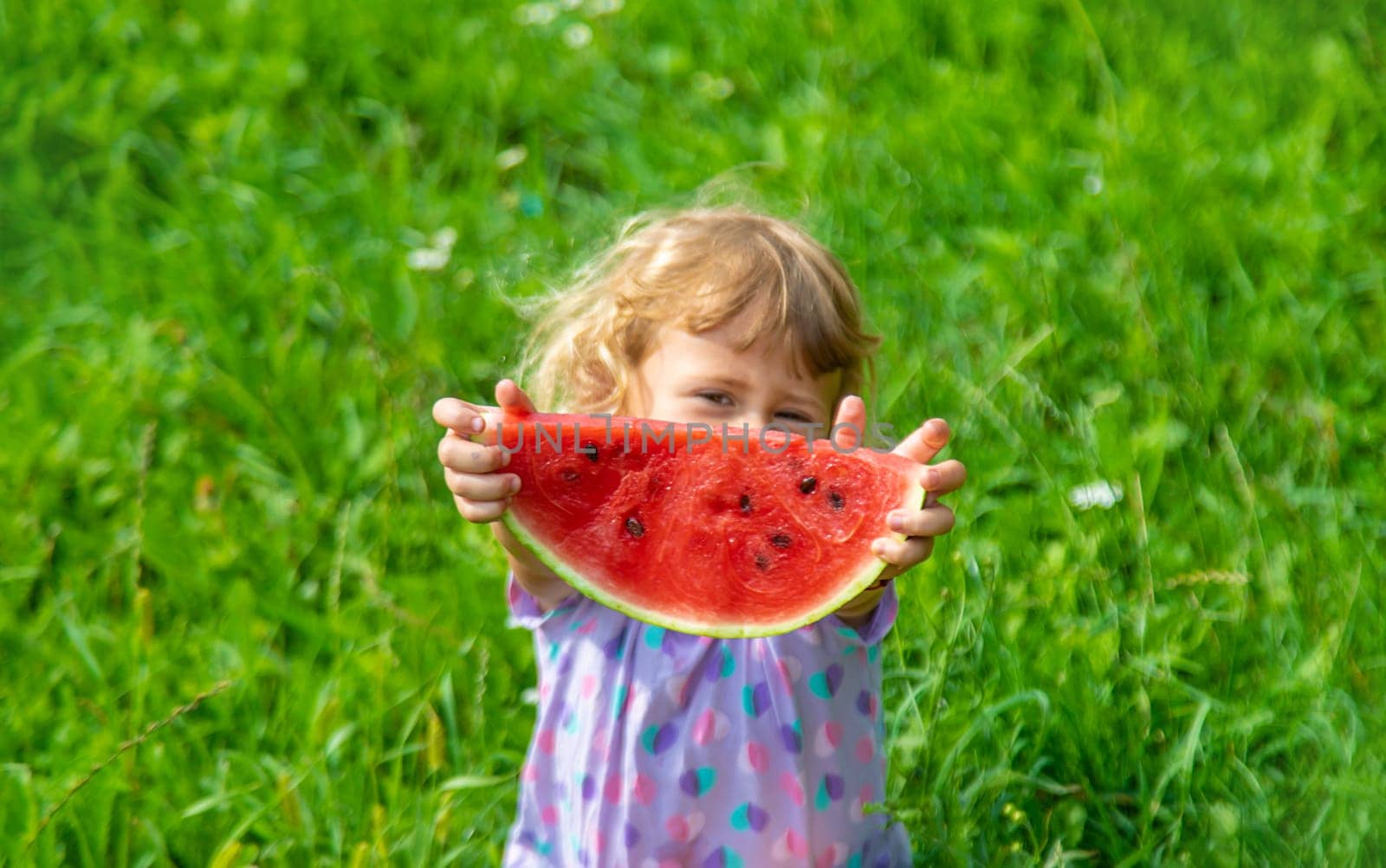 Child eats watermelon in summer. Selective focus. Kid.