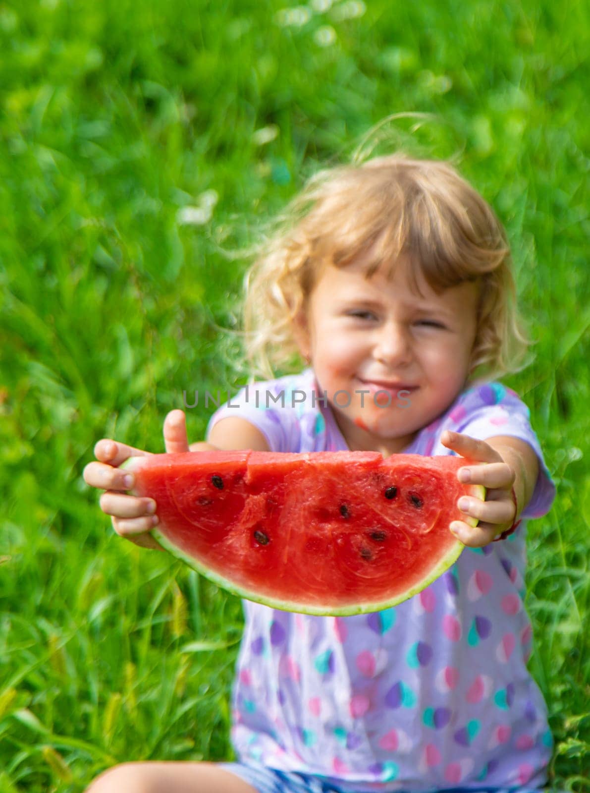 Child eats watermelon in summer. Selective focus. Kid.