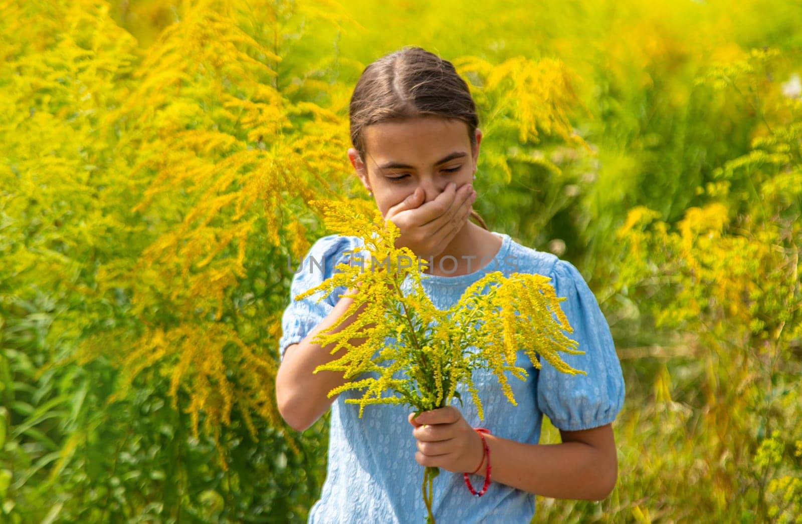 Child in ragweed flowers allergy. Selective focus. Kid.