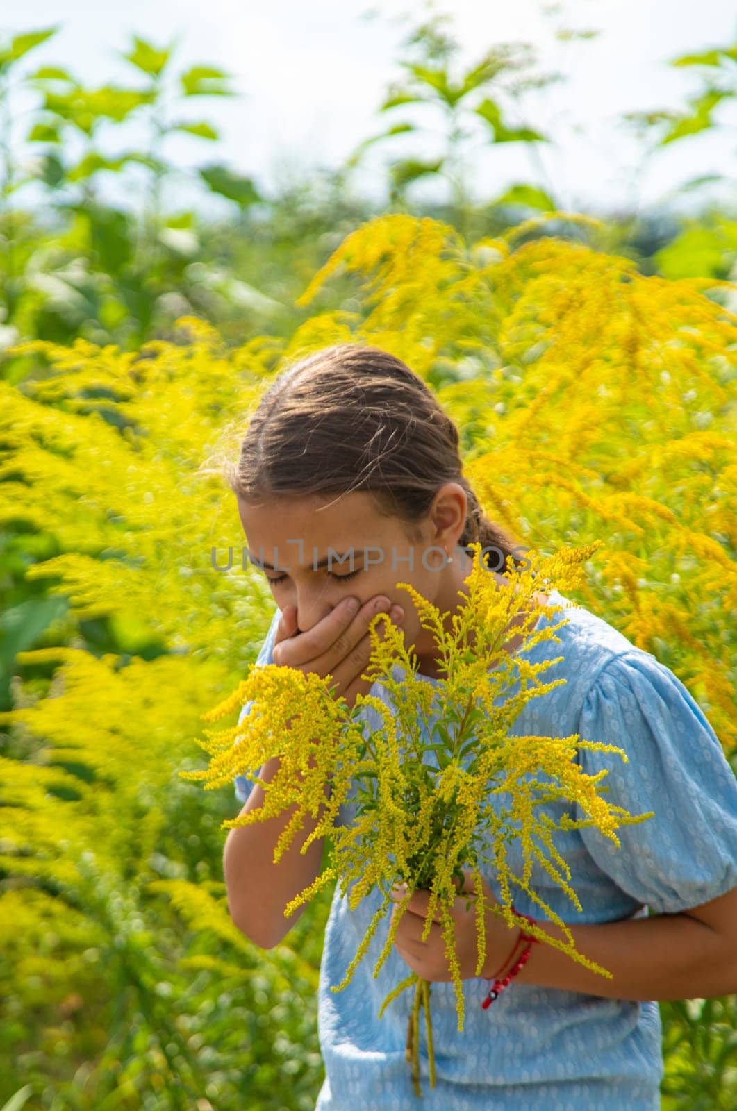 Child in ragweed flowers allergy. Selective focus. Kid.