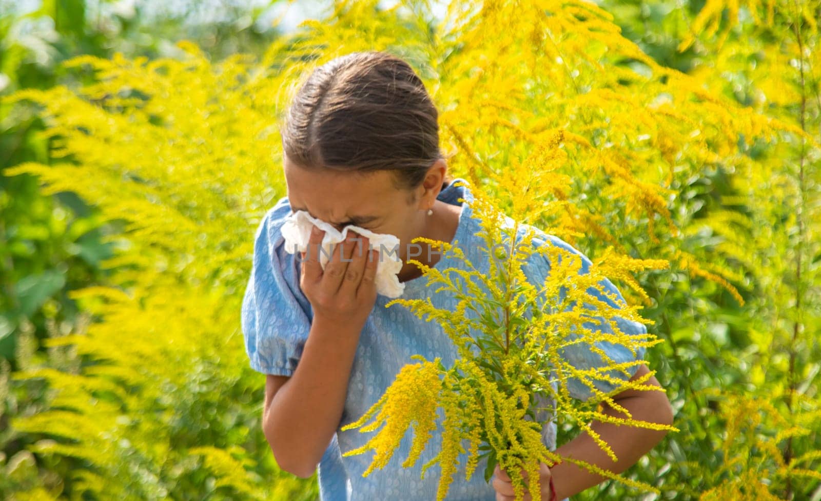 Child in ragweed flowers allergy. Selective focus. Kid.