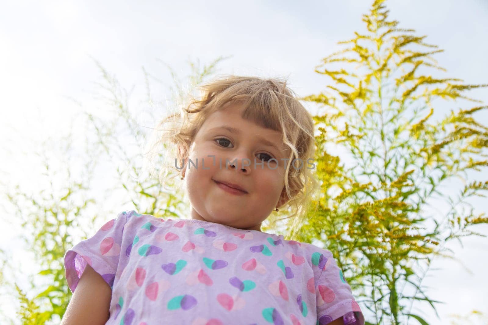 Child in ragweed flowers allergy. Selective focus. Kid.