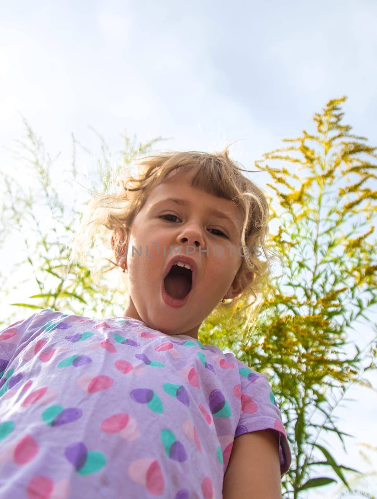 Child in ragweed flowers allergy. Selective focus. Kid.