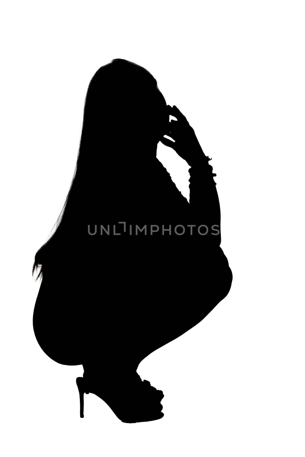 A graceful silhouette of a woman creatively squatting down with her hand thoughtfully resting on her face in a contemplative pose