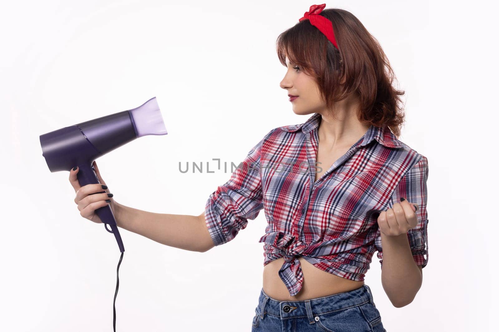 A fashionable and stylish woman confidently demonstrates her beauty routine while using a hair dryer with ease