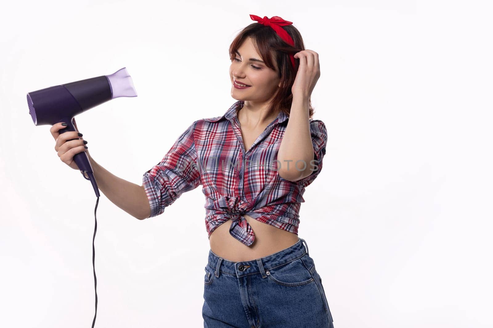 A stylish and fashionable woman is expertly using a hair dryer, perfectly embodying the latest modern beauty trends