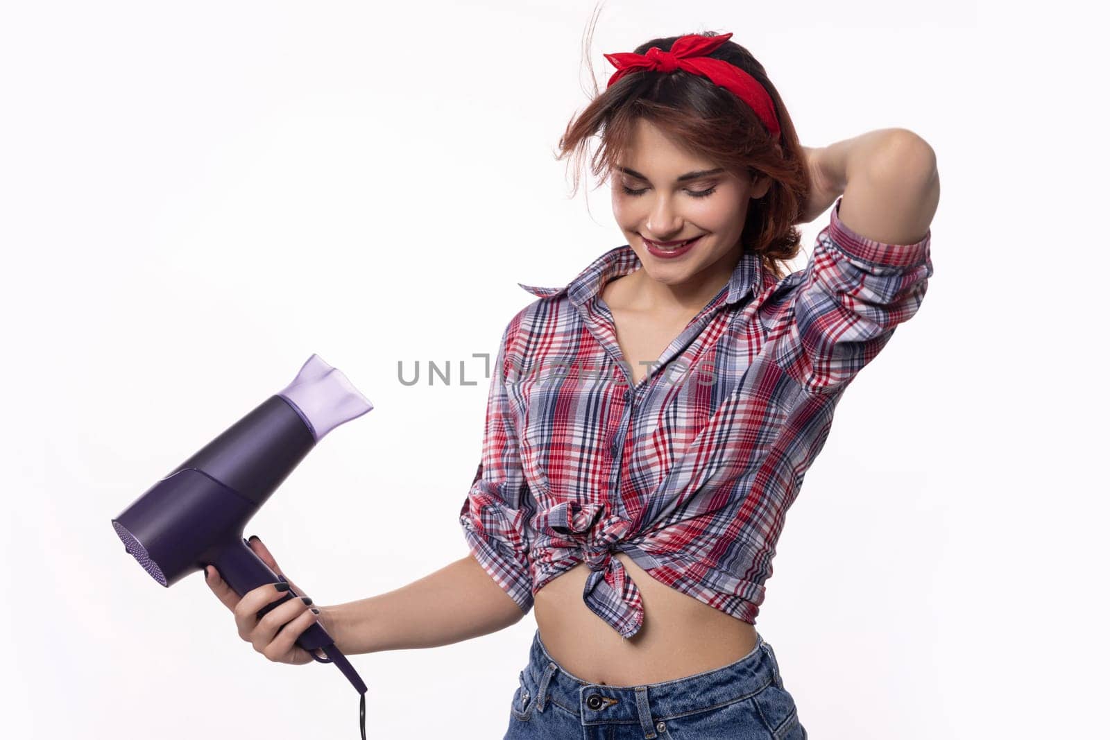 A trendy woman is actively using a hair dryer, wonderfully showcasing the art of contemporary hairstyling