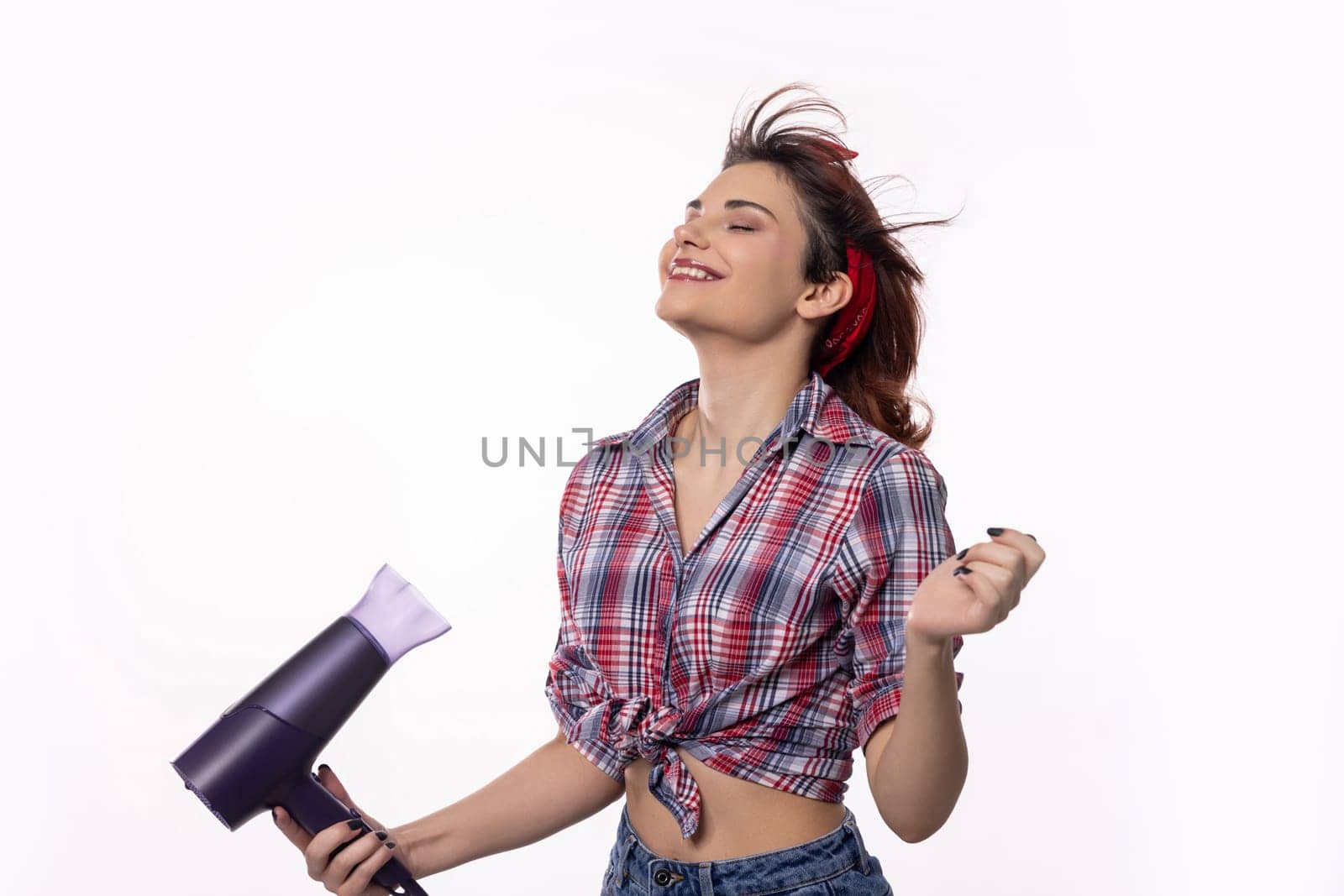 A young woman is playfully drying her hair while exuding both confidence and pure joy in her expression