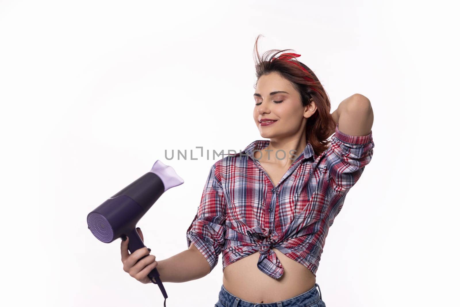A chic and fashionable woman confidently showcases her daily beauty routine while using a hair dryer