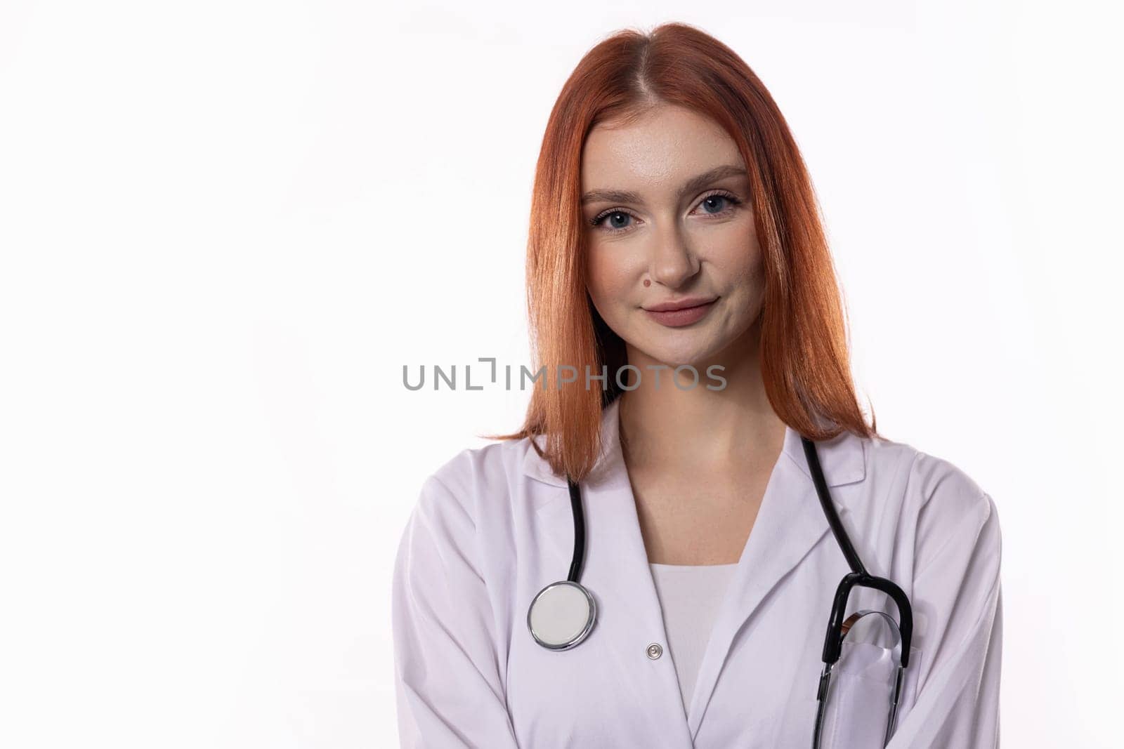 A confident female doctor in a white lab coat with a stethoscope is ready for patient care and support