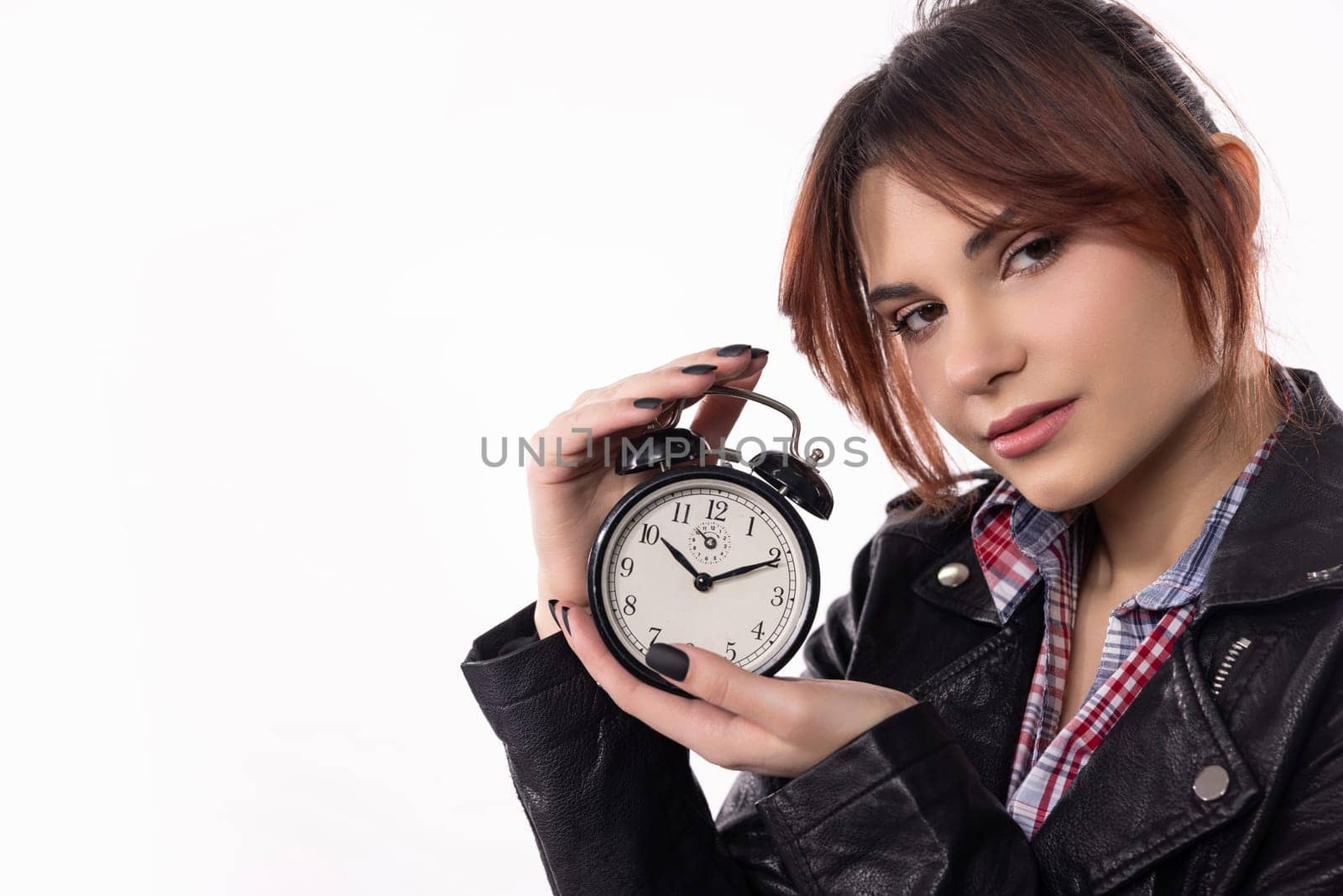 A young woman poses with a stylish alarm clock, highlighting her trendy fashion and time management theme