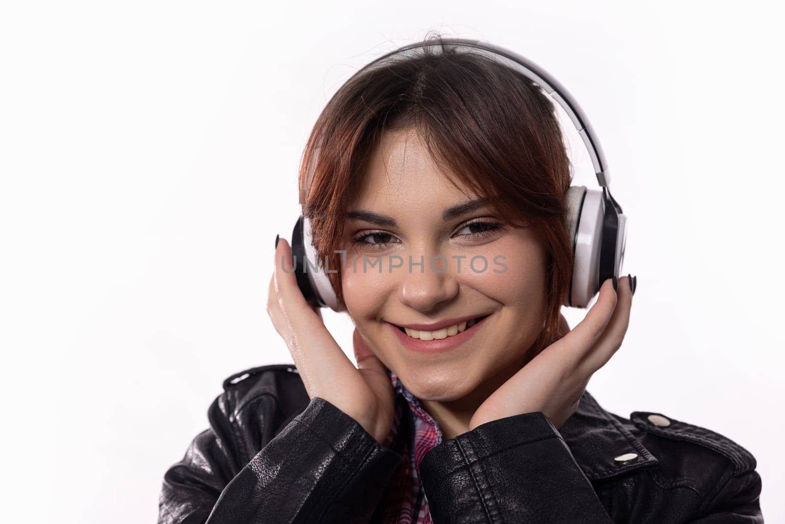 A cheerful young woman, fully immersed in her music while wearing headphones, radiates a bright and joyful smile