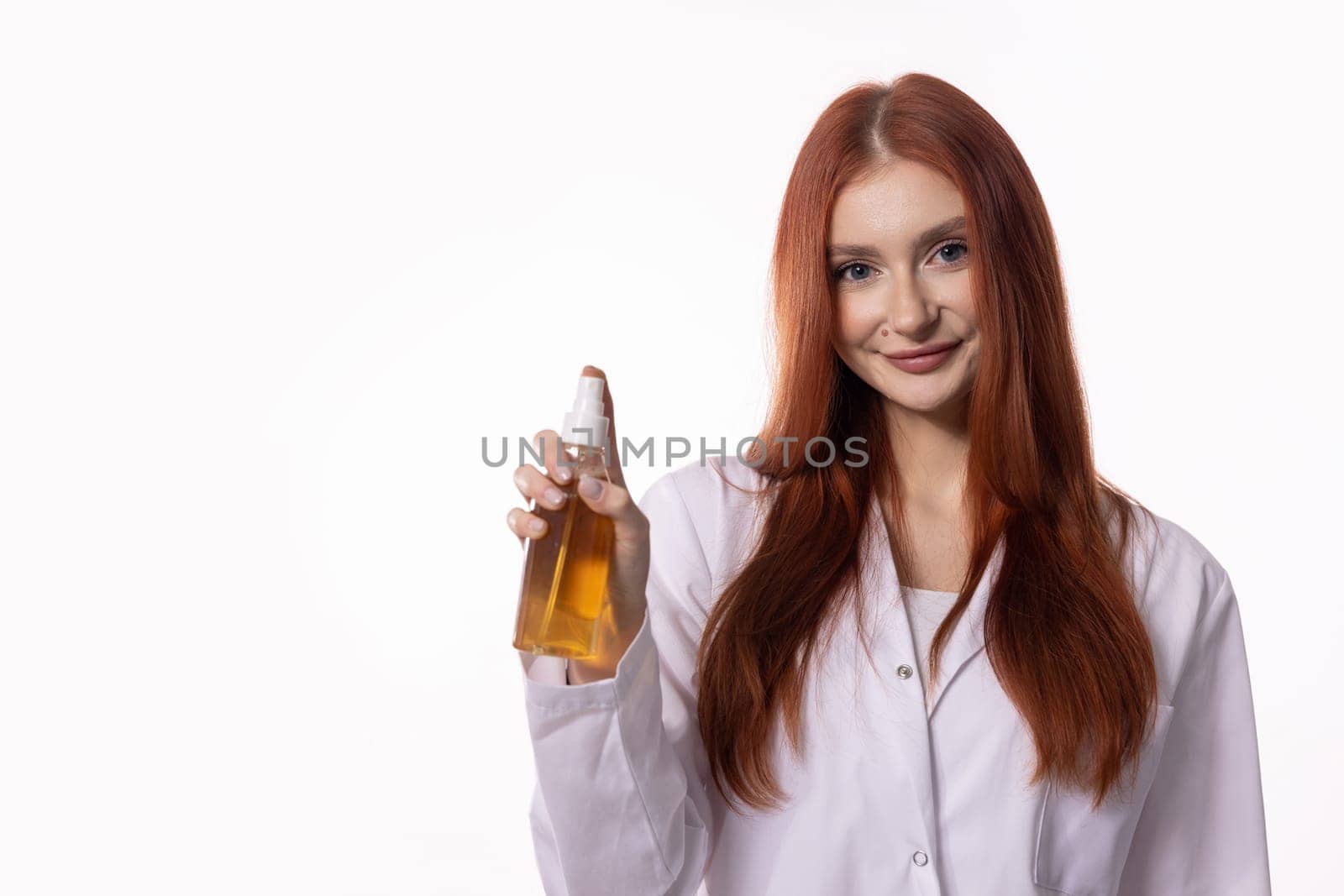A confident woman in a lab coat showcases a nourishing oil in a professional setting, exuding expertise and style