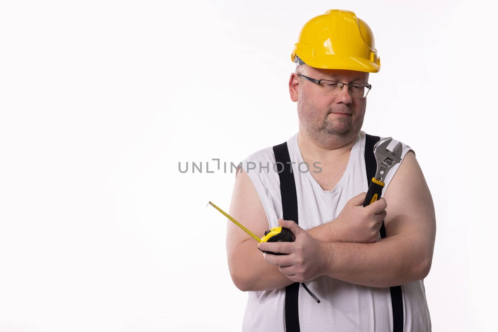 A confident construction worker poses with tools, prepared and ready for the job in a casual outfit