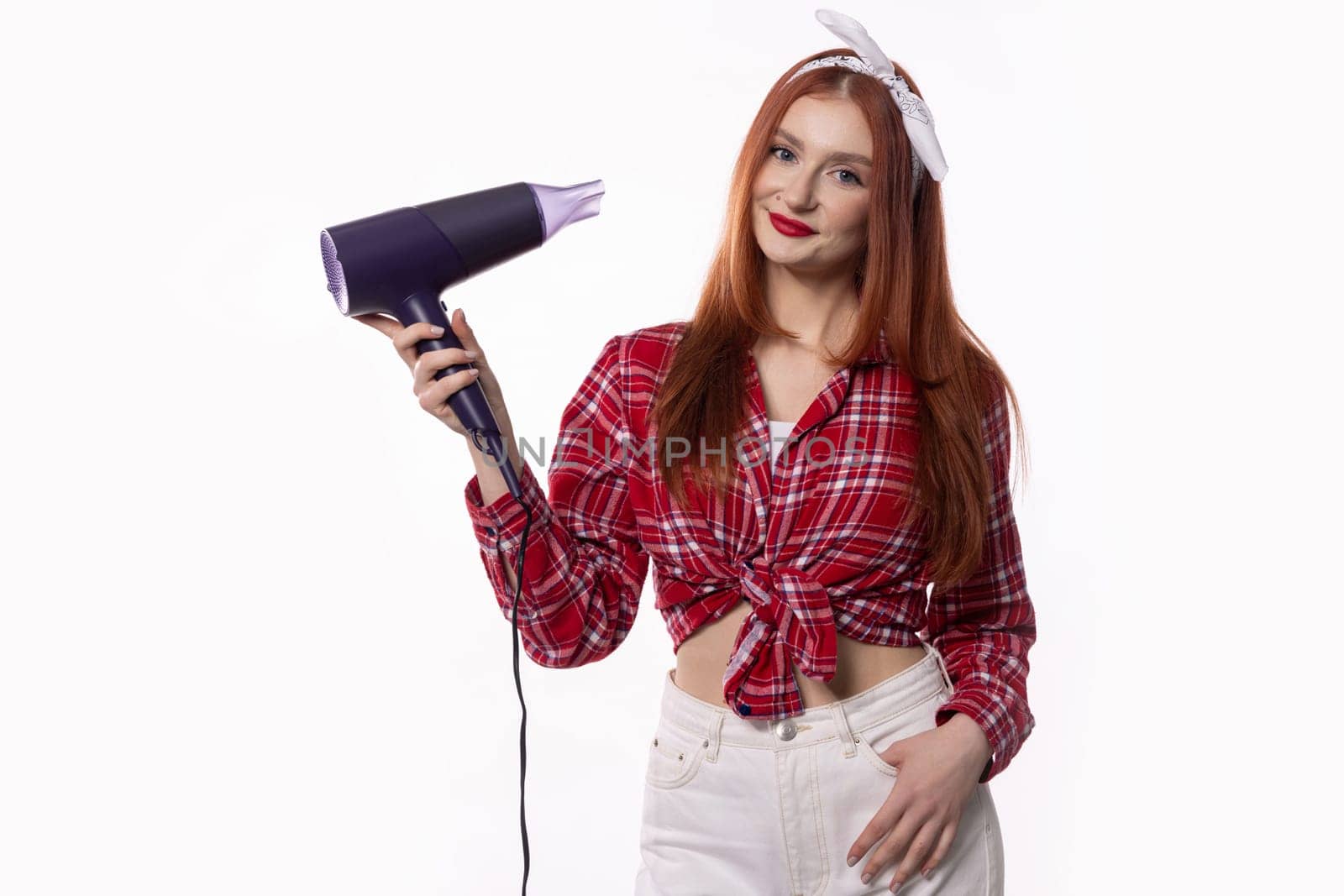 A fashionable and stylish woman confidently poses with a hair dryer, showcasing a modern, chic, and trendy hairstyle