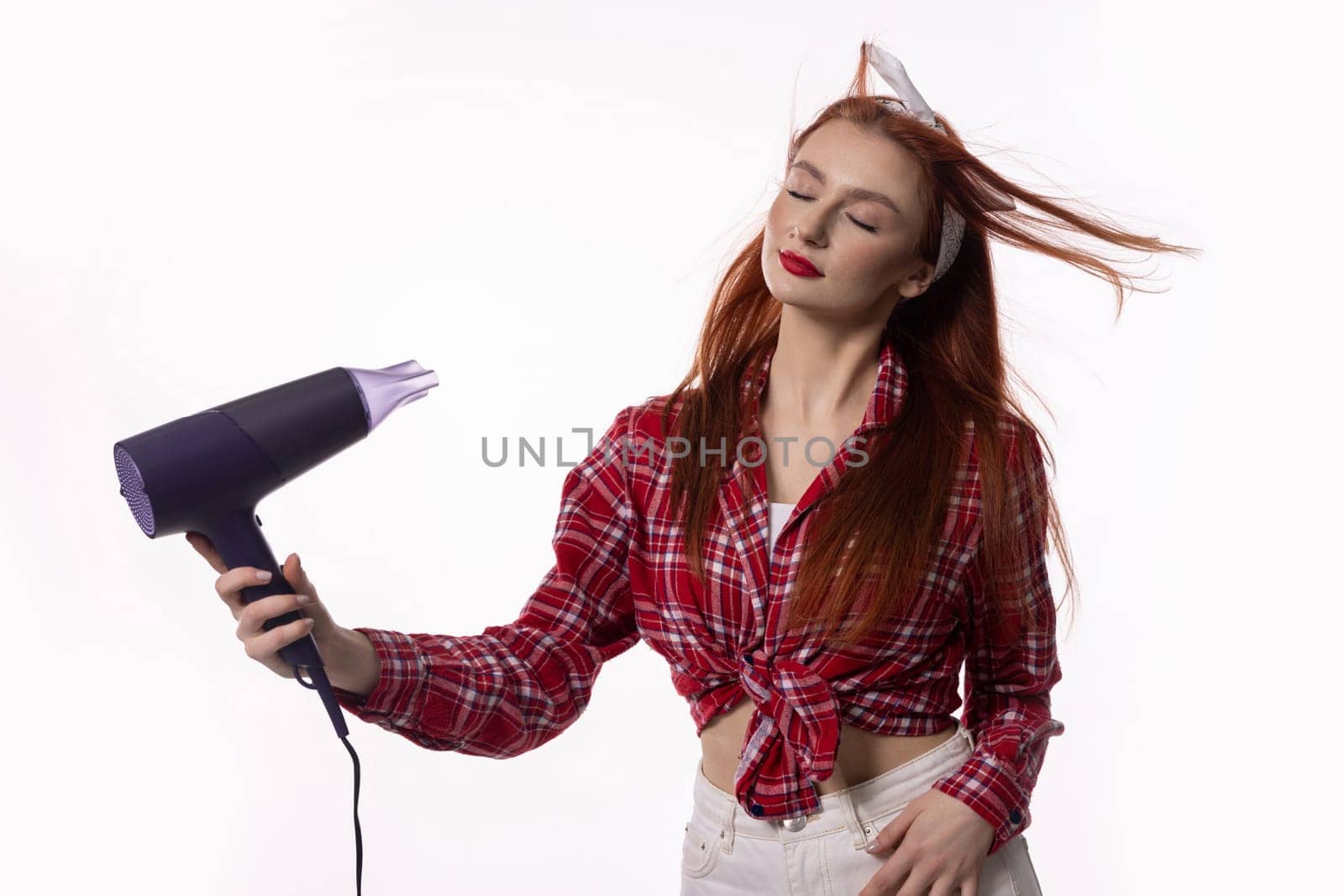 A woman with long, flowing hair is using a hair dryer, projecting an incredibly confident and trendy vibe