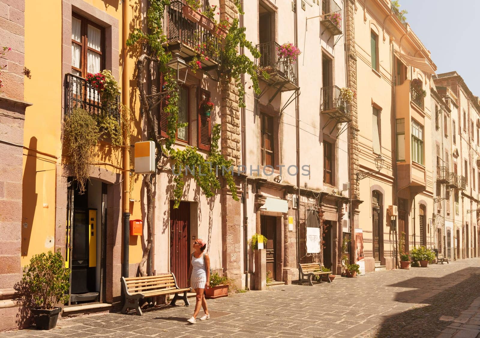 Female tourist walking through the streets of Bosa. Sardinia, Italy