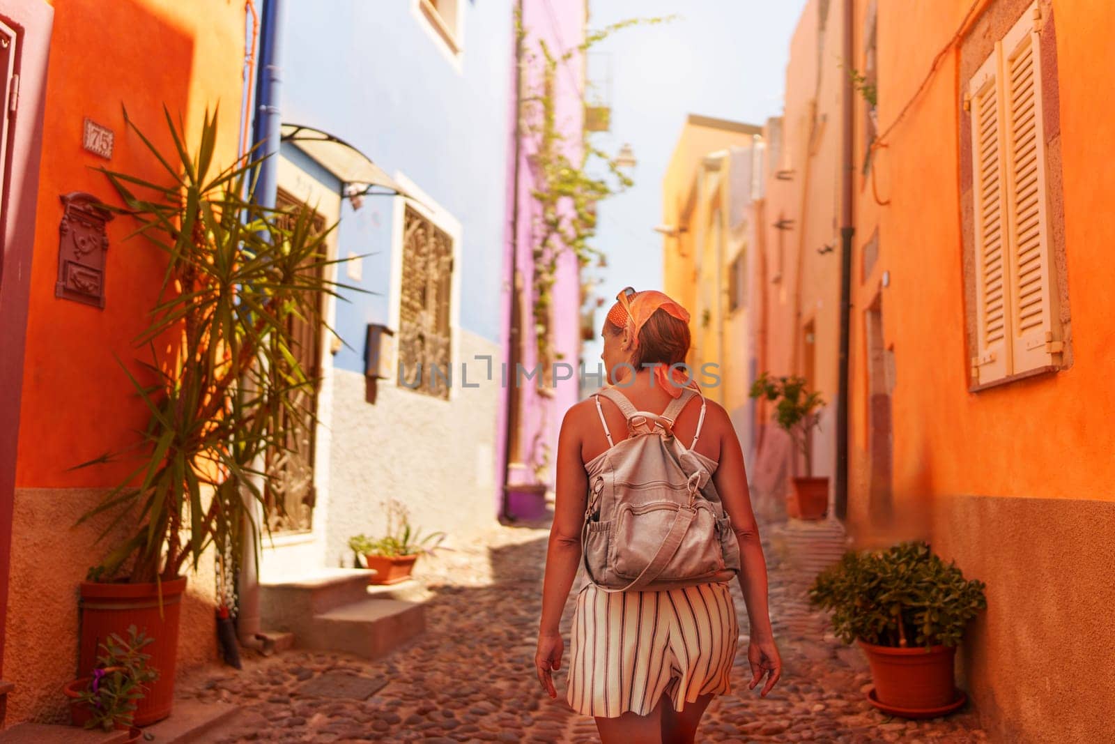 Female traveler walking through the streets of Bosa. Sardinia, Italy