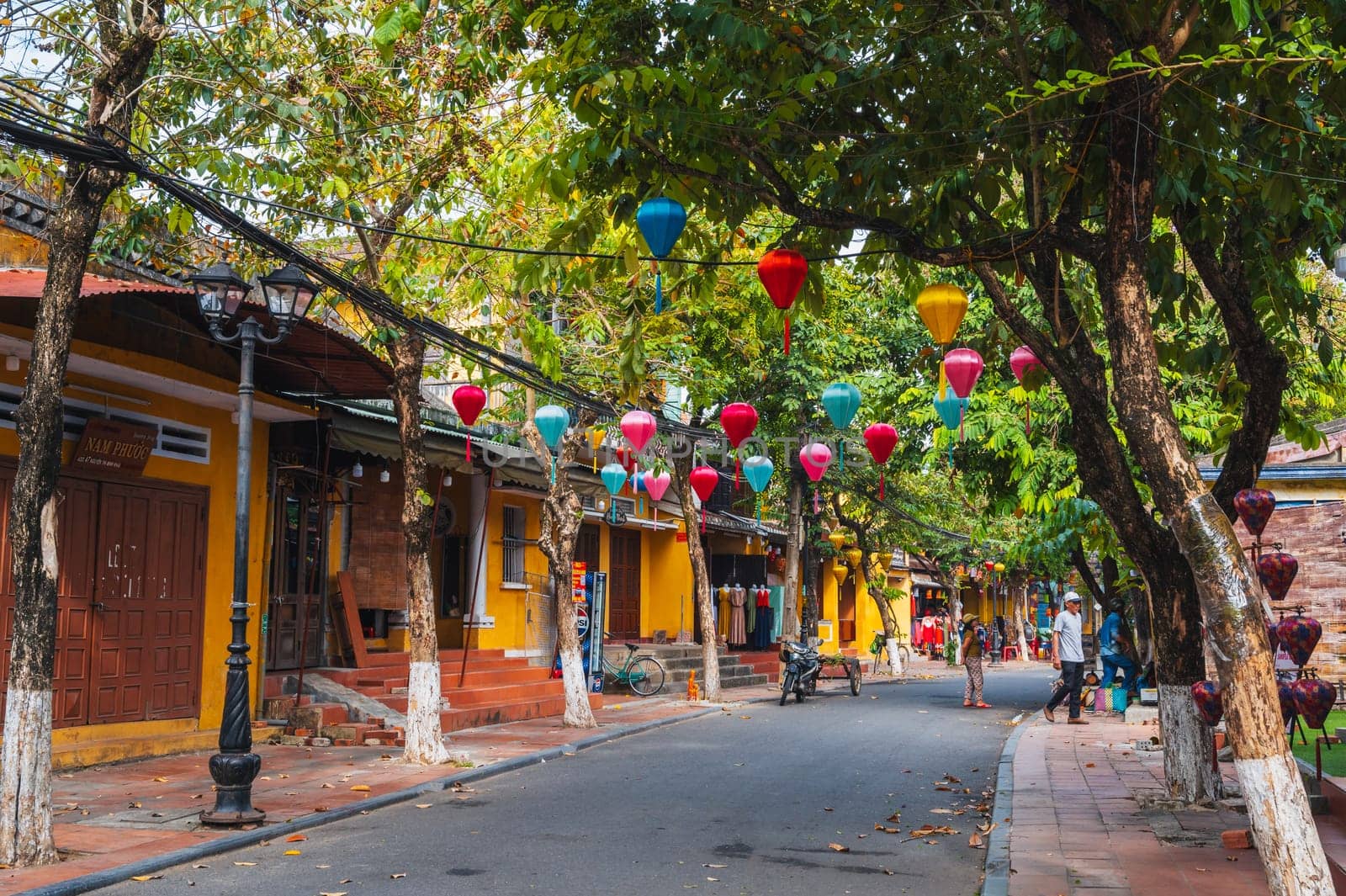 Beautiful ancient asian streets in the old town of Hoi An city with historic houses and green trees. Hoi An, Vietnam - September 12, 2024